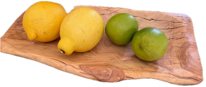 Un vassoio da portata in legno d'olivo dal bordo naturale, con limoni e lime